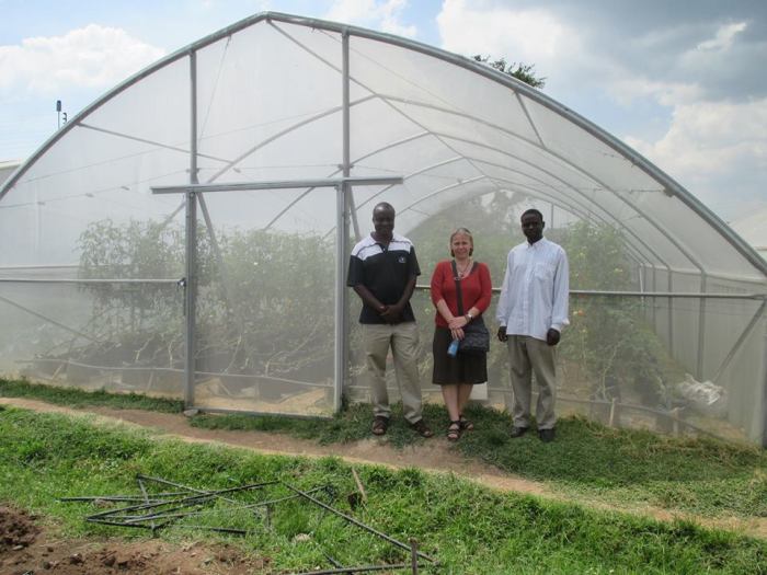 Jonna samen met Dickson en een familielid vóór de aangekochte serre